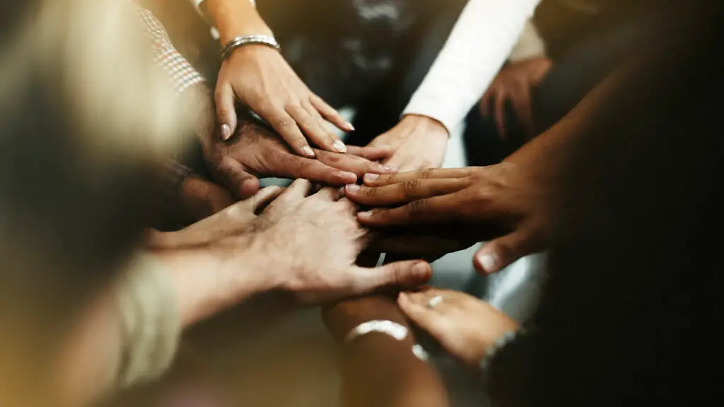 equipe reunida de mãos dadas